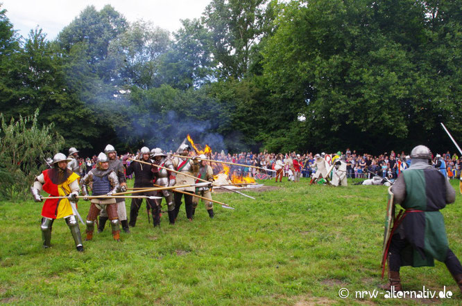 Kämpfende Ritter, im Hintergrund Publikum.