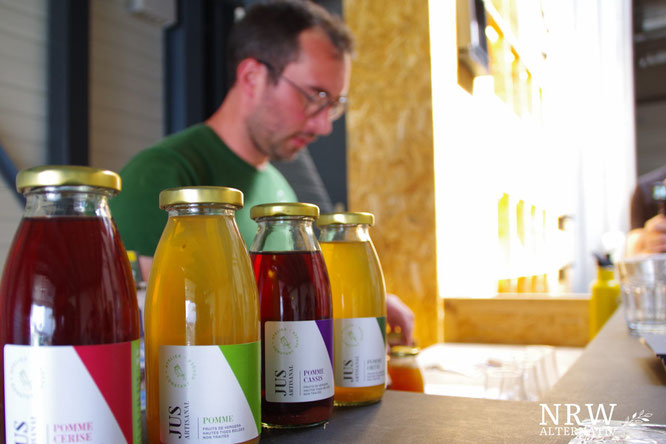 Flaschen mit Apfelsaft und ein Mann im Hintergrund. 