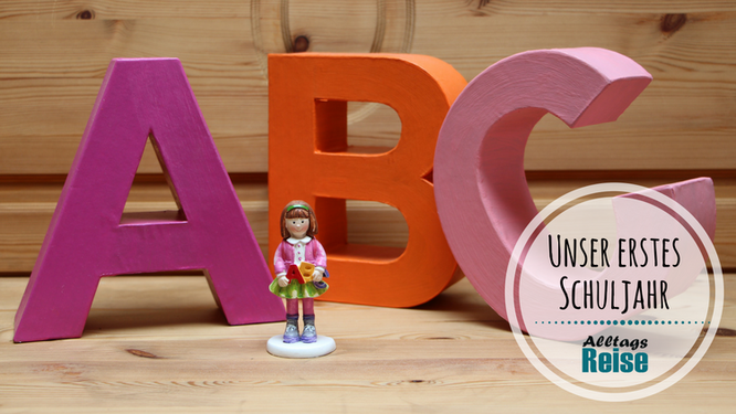 Drei große bunte Pappbuchstaben "A-B-C" und eine kleine Schulmädchenfigur