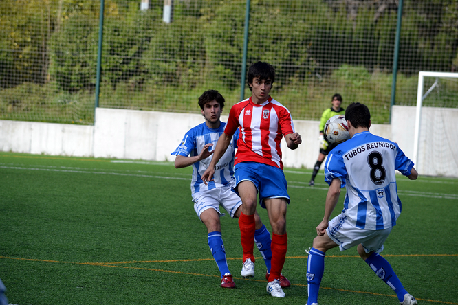 Joseba Pérez ante dos futbolistas blanquiazules en el duelo entre el Laudio B y el Amurrio de la temporada 2012-13.