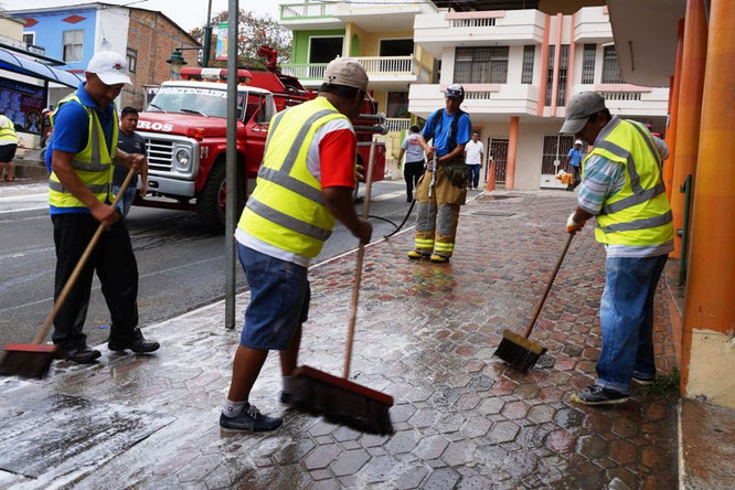 Bomberos lavan calle usada para la feria comercial popular de noviembre. Montecristi, Ecuador.