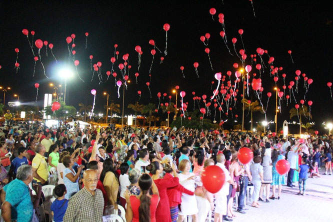 Elevando globos rojos desde la plaza cívica, durante la representación del musical "Una Oración al Cielo". Manta, Ecuador.