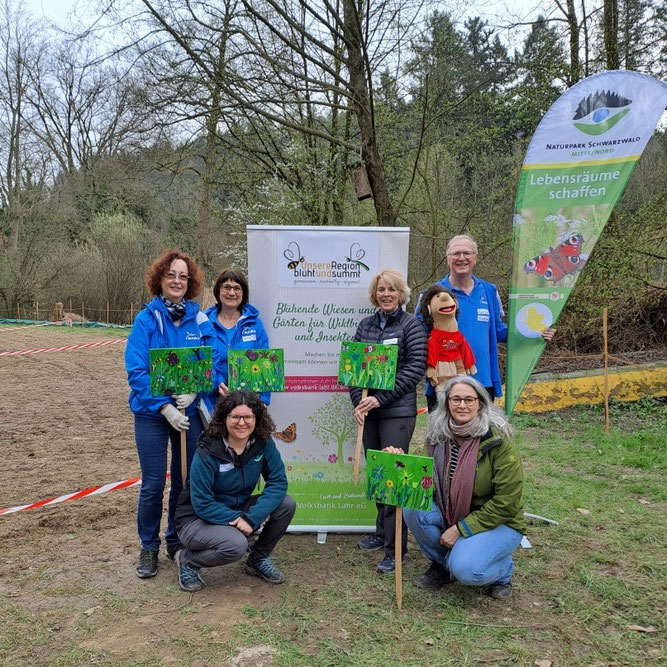 Blumenaussaat-Aktion beim Hohbergsee, NABU Lahr: Regina Erb-Schalk, Astrid Eckenfels (beide NABU Lahr), Lilli Wahli vom Naturpark Schwarzwald Mitte/Nord, Susanne Hauser, Daniela Becker (beide von der Volksbank) und Handpuppe Rico mit Harry Huhn (NABU Lahr