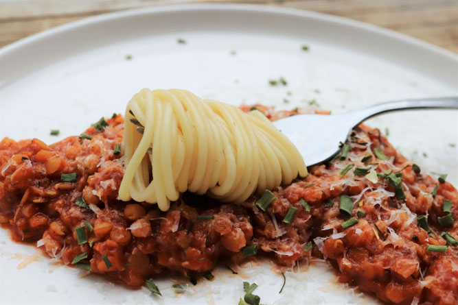 vegetarisches Linsensugo mit einer Gabel voll Nudeln