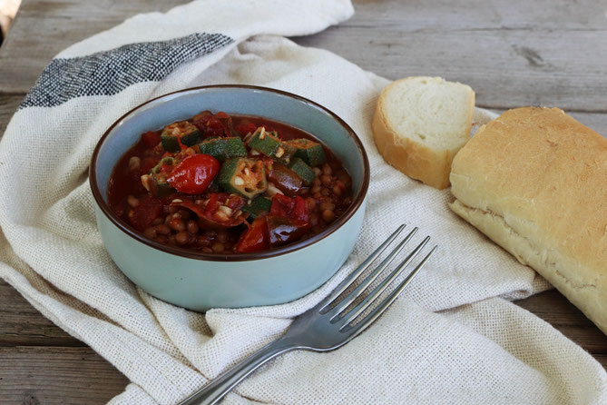 Okraschoten in Tomaten-Linsentopf auf einem Tisch