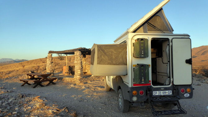Le Bush Camper avec le toit ouvert et le lit déplié sur le côté 