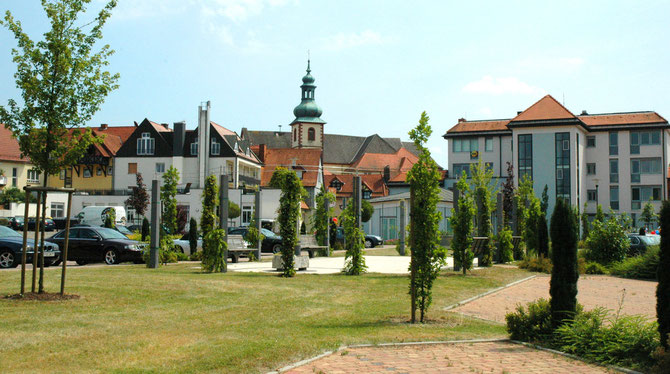 Hinter dem Rathaus in Flieden mit Sicht auf die Kirche St. Goar und den Bäcker Happ - WIFO Flieden