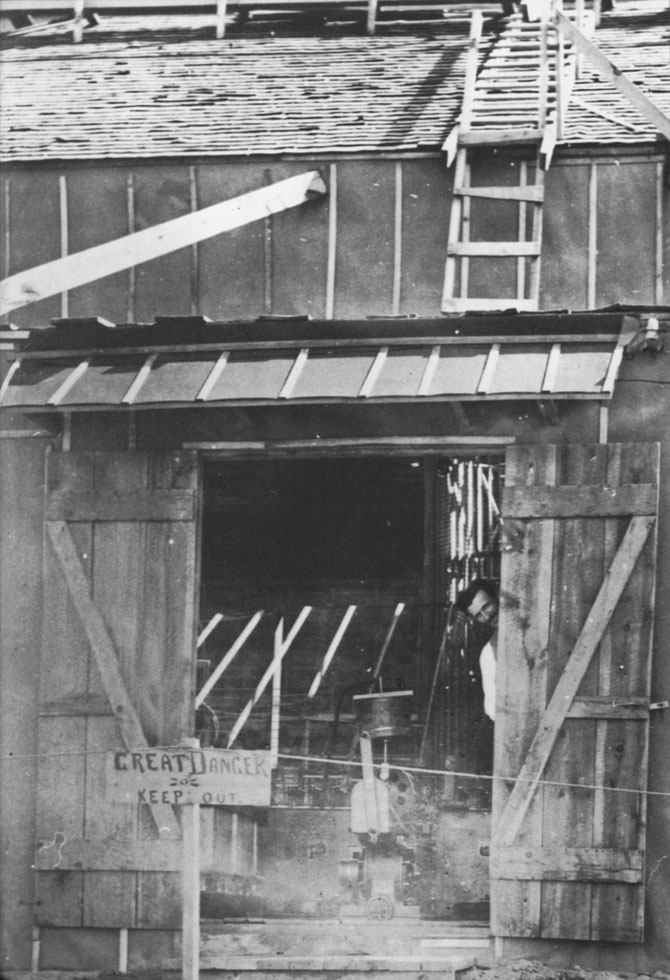 Tesla peeks out the door of the Colorado Springs Laboratory. Early summer, 1899.