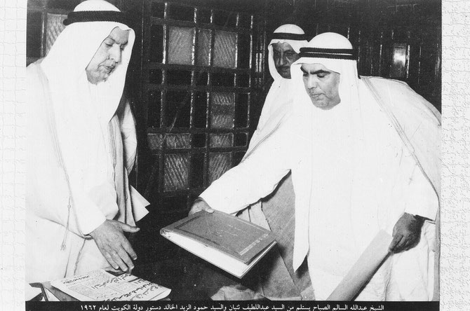 SON ALTESSE L'EMIR ABDULLAH III RECOIT LE PROJET DE LA CONSTITUTION DU KOWEÏT      (COMPORTANT 183 ARTICLES) DE LA PART DU REDACTEUR.    LA CONSTITUTION FUT APPROUVEE ET PROMULGUEE LE 11 NOVEMBRE 1962.