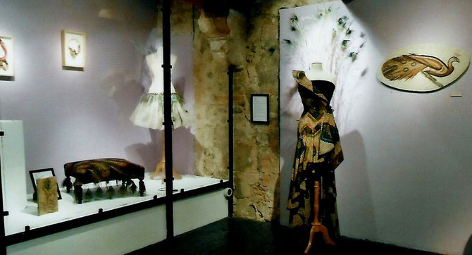 A gauche. SYLVIE KAMENI : "LA PARADE", robe en tissiu africain et plumes de paon. A droite, au mur : VANINA MERCURY : "PAON" D'après une mosaîque du MUSEE DU BARDO-TUNIS