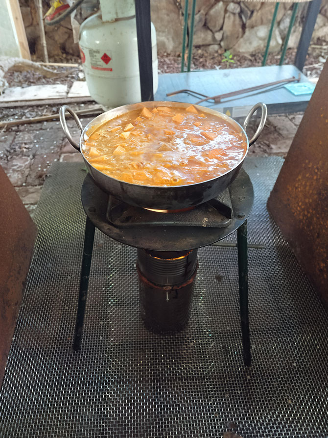 The Permastove V4 with Champion pot stand slow cooking a curry in a Kadhai last biochar season