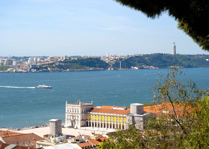 Blick auf Almada mit der Christus Statue. Im Vordergrund der Praca do Comercio, umrahmt von den wichtigsten Ministerien