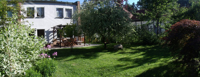 Blick auf die Ferienwohnung mit ihrer überdachten Südterrasse und dem gemütlichen Garten