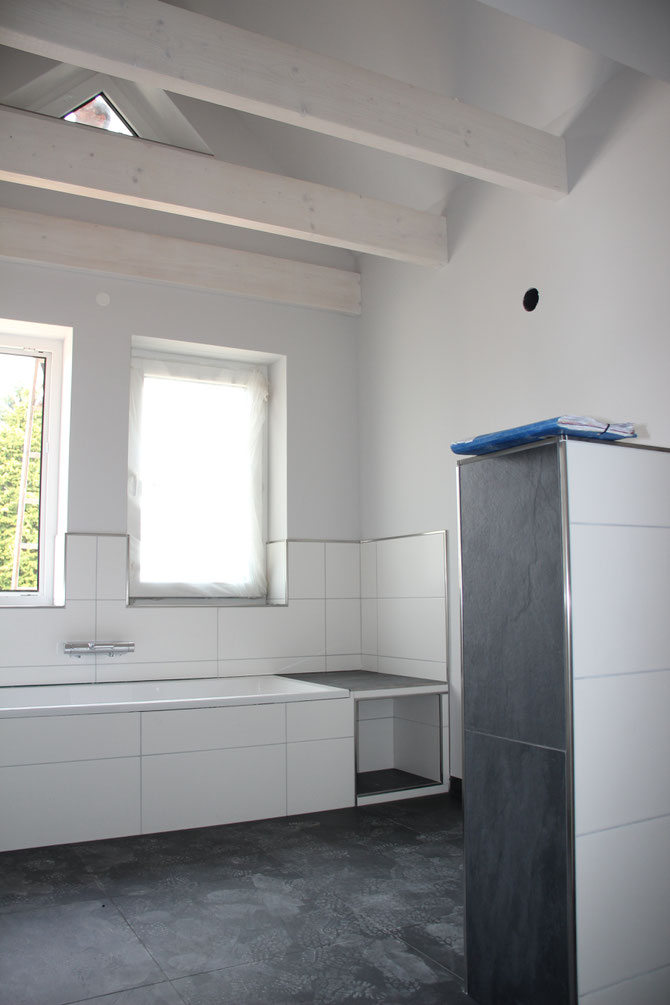 Das Badezimmer erhält einen leichten Grauton, die Holzbalken werden weiß gekalkt.
