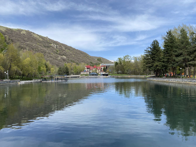 lago termale di Jermuk, circondato da foreste e un piccolo hotel sullo sfondo, in Armenia