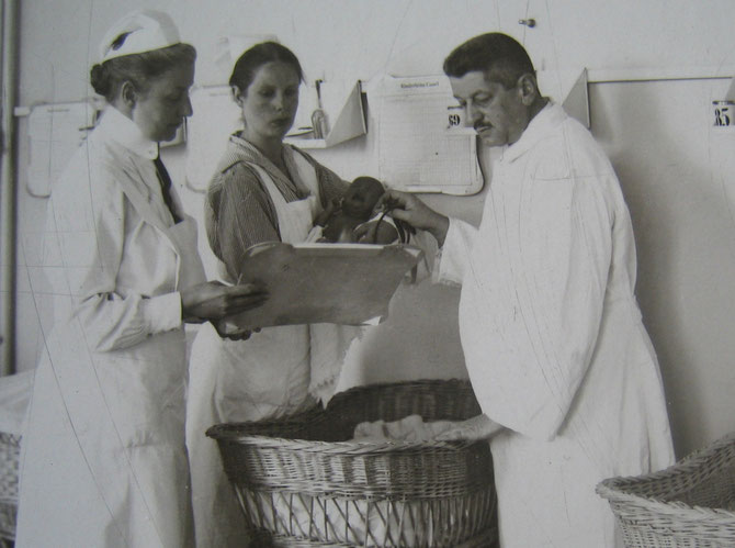 Dr.Felix Blumenfeld mit zwei Krankenschwestern und einem Säugling