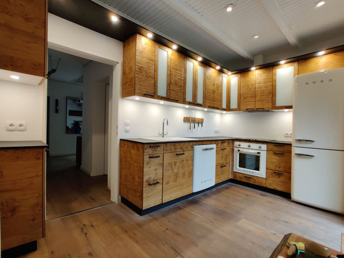 Küche mit rustikaler Holzobtik und weißen Akzienten, Oberbeleuchtung durch Strahle