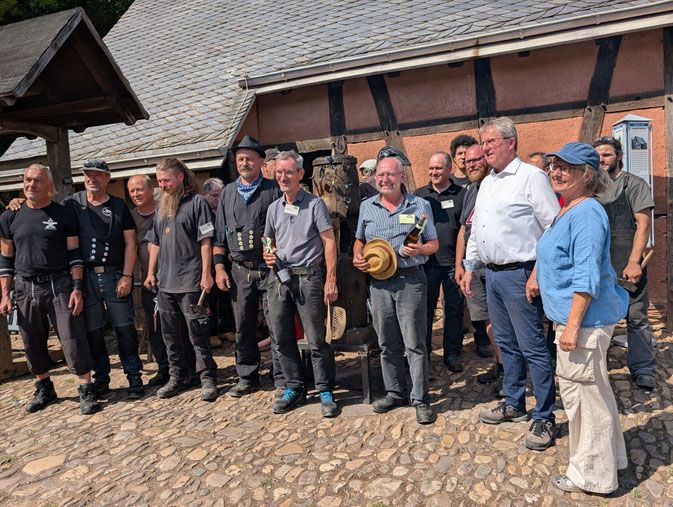 Die versammelten Museumsschmiede beim „Funkenschlag“ 2025 zusammen mit den Organisatoren Volker Priewe und Alexander Storck  sowie den Ehrengästen