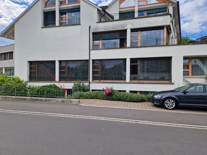 Eingang zur Männercoaching-Praxis von Marco Ehrat im Untergeschoss des Altersheim Früeling in Beringen; roter Pfeil markiert den Zugang hinter der Hecke.