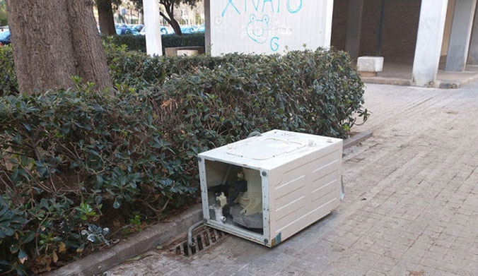 Lavadora abandonada en  la  acera de una  calle de la ciudad de Valencia.