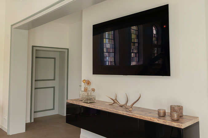 Deko-Details und Fernseher in der modern als Ferienhaus ausgebauten "Kleinen Kapelle"