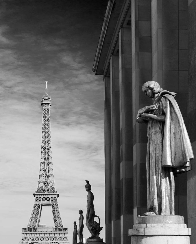 Black and white photograph of stone sculptures in front of the Eiffel Tower, Paris, France 