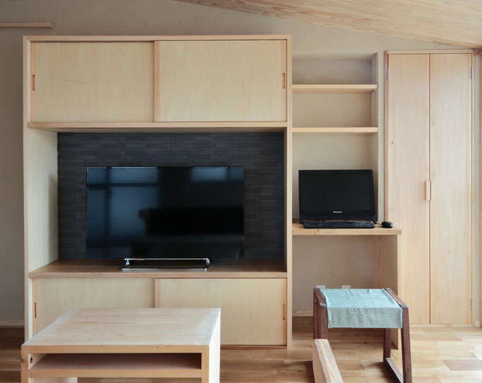 造作のテレビボードの背面には、アクセントにエコカラットを貼っています