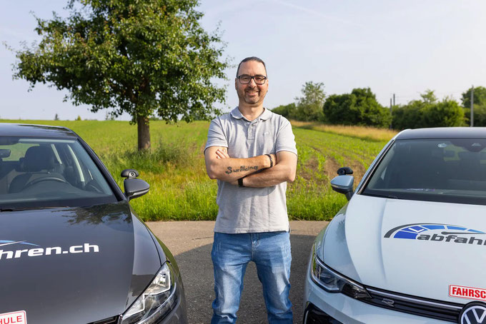 Fahrlehrer in Bubikon vor beiden Fahrschulautos – Abfahren.ch