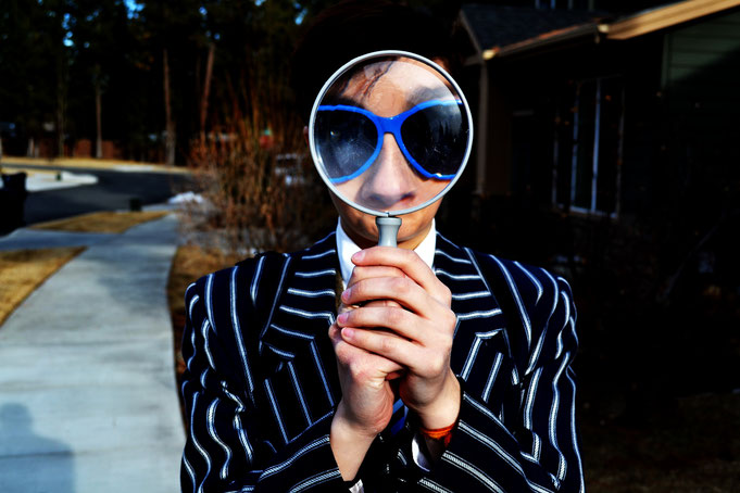 Man with magnifying glass in front of his face