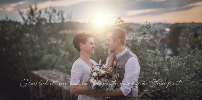 Hochzeitspaar bei Sonnenuntergang sehen sich verliebt in die Augen. Im Hintergrund das malerische Mattsee.