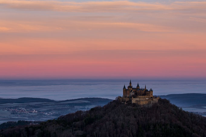 Farbenfroher winterlicher Sonnenaufang; im Hintergrund hat sich in der Nacht Bodennebel gebildet.