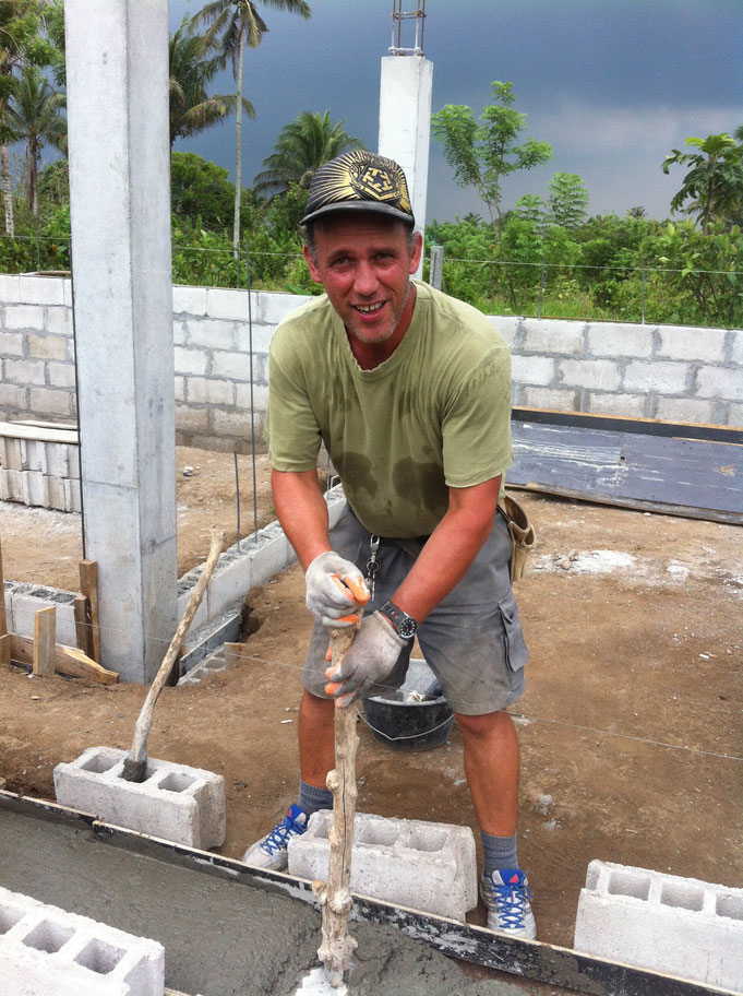 Ein Mann vibriert Beton mit einem Stampfer