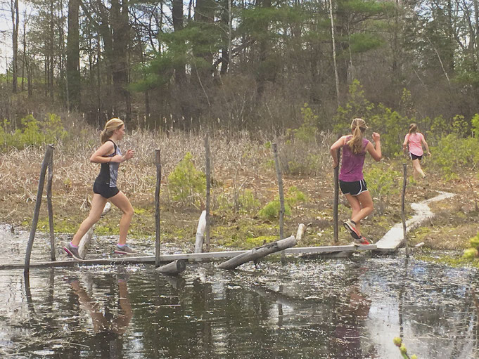 The Surry Village Charter School track team using Distant Hill Nature Trail for training. Here they are running across the narrow boardwalk that crosses the cranberry bog.