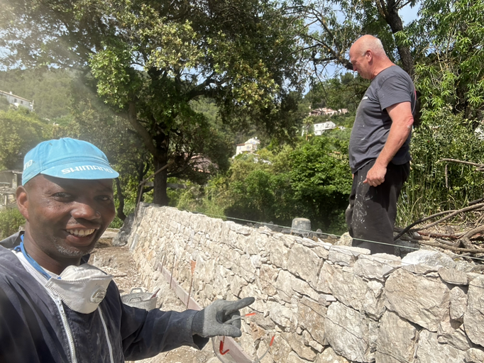 Maçon JMC BAT construisant un mur en pierre de taille à Saint-André-de-la-Roche