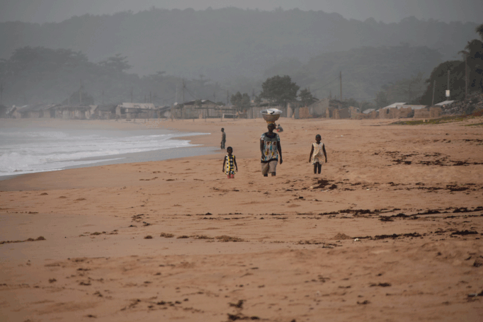 Eine Marktfrau mit ihren Kindern am Strand