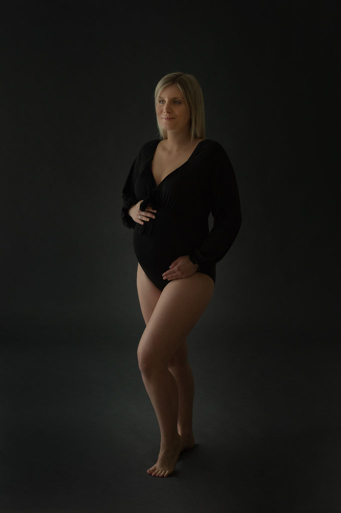Schwarzer Body kleidet Schwangere beim Shooting