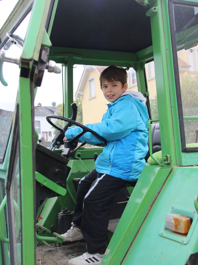 Dario vom Haus St. Martin lernt das Cockpit des Traktors kennen