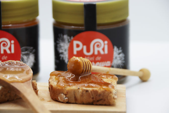 Photo d'une cuillère en bois spéciale pour manger du Miel liquide, le Miel sur la cuillère est le Miel de Rewarewa de Nouvelle-Zélande