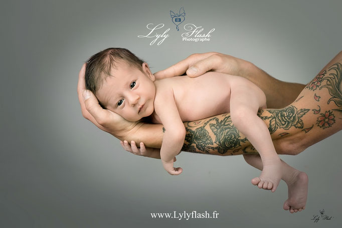 photo de naissance d'un nouveau-né sur bras de papa avec un bébé parfait par la photographe du var 83 près de Toulon  studio photo