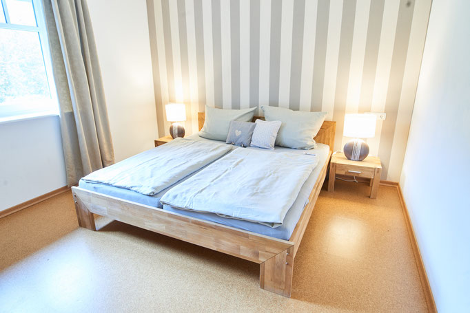 Helles freundliches Schlafzimmer mit Doppelbett der Ferienwohnung "Am großen Findling" auf dem Imkershof der Familie Röhrs in Schneverdingen-Surbostel