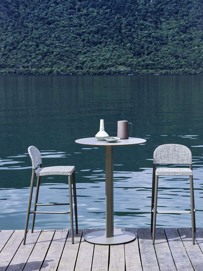 Tavolo alto da esterno con sgabelli su pontile vista lago, soluzione outdoor per zona conviviale.
