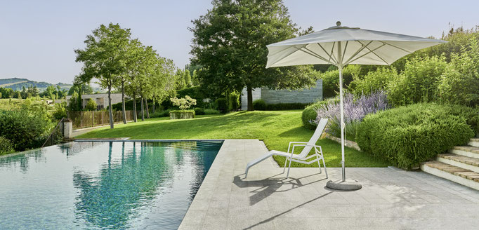 Lettino prendisole e ombrellone a bordo piscina, arredo outdoor per giardino panoramico.
