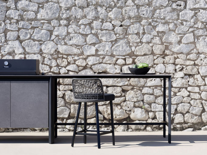 Tavolo outdoor con sedia intrecciata vicino piscina, arredo da esterno per zona pranzo.