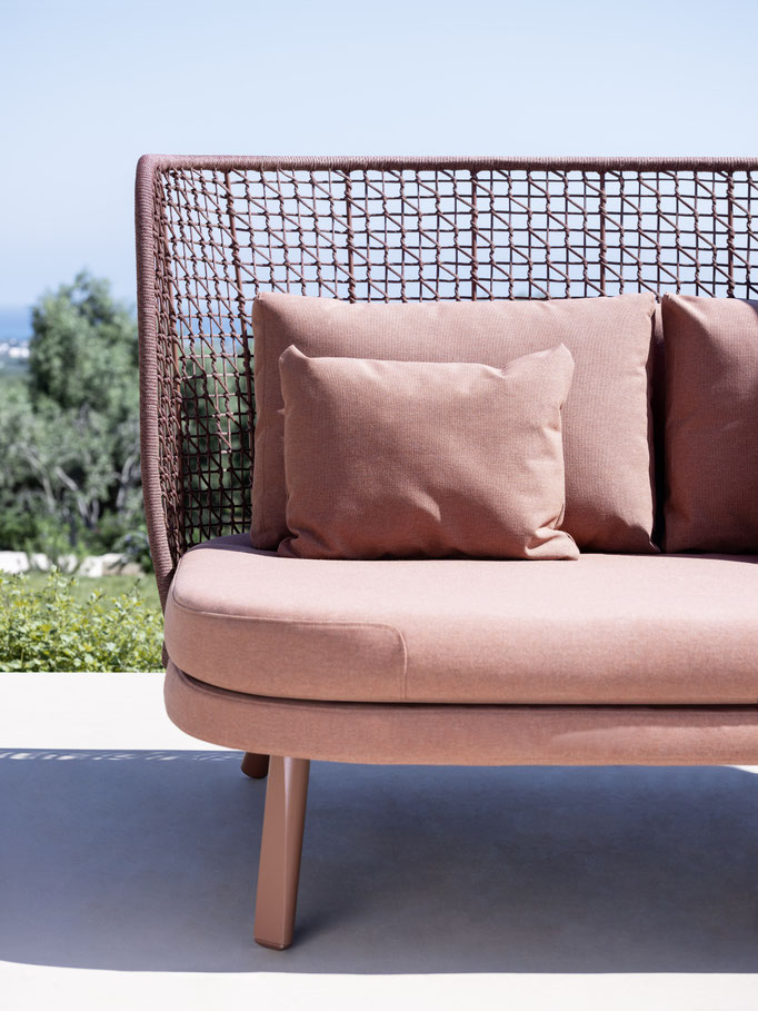 Divano outdoor rosa con struttura intrecciata e cuscini coordinati, seduta elegante per terrazze e giardini.