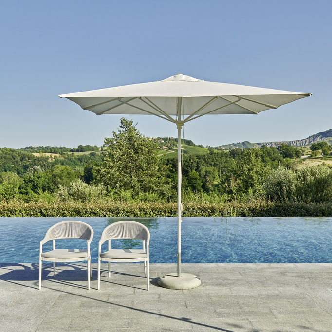 Ombrellone da esterno con sedute outdoor a bordo piscina, soluzione per relax e ombra in giardino.