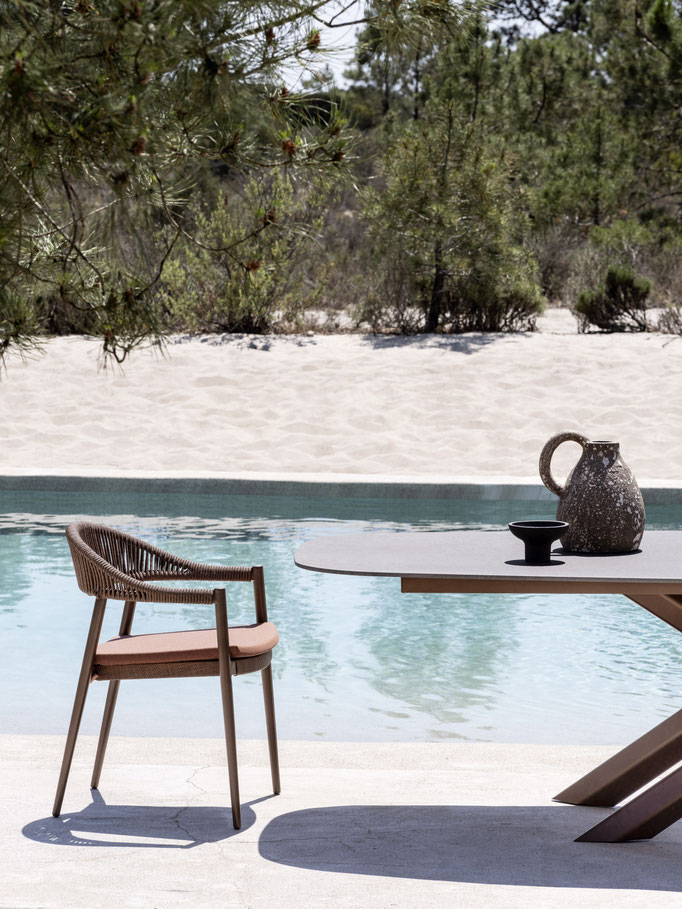 Sedia outdoor intrecciata vista piscina, dettaglio di seduta da esterno con struttura resistente.