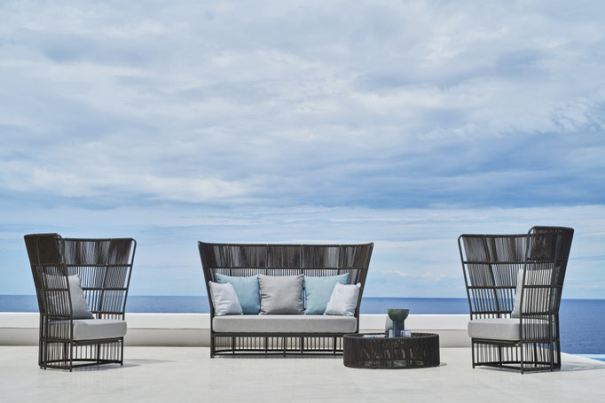 Salotto Varaschin outdoor vista mare con divano, poltrone alte intrecciate e tavolino per zona relax da esterno.