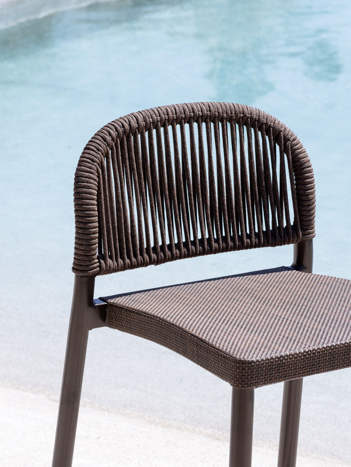 Sedia outdoor intrecciata vista piscina, dettaglio di seduta da esterno con struttura resistente.