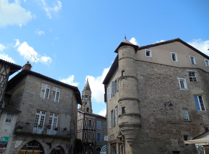 Vue la plus pittoresque Place de la République : maison médiévale en partie préservée (à gauche), maison à la tour ronde (du XVIIe siècle) et au fond le clocher de la collégiale.