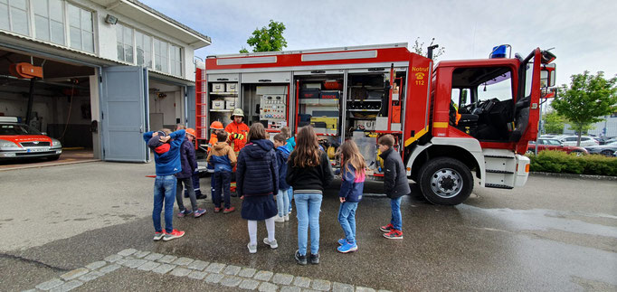 Den Kindern wird ein Feuerwehrauto von außen erklärt